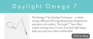 Promotional banner with a turquoise header reading ‘Daylight Omega 7.’ An image of a Daylight Omega 7 magnifying lamp appears on the left, with text reading "the omega 7 by daylight company - a sleek, energy efficient led magnifying lamp designed for precision and comford. the large 7" lens offers ample viewing area. its cool, low-head light keeps both you and your client comfortable.", on the right, along with a gray button labeled ‘click to shop.’